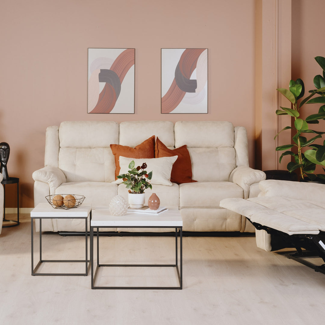 Minnesota sofa i lys beige stoff med recliner, i rom med rosa vegg, settbord og planter