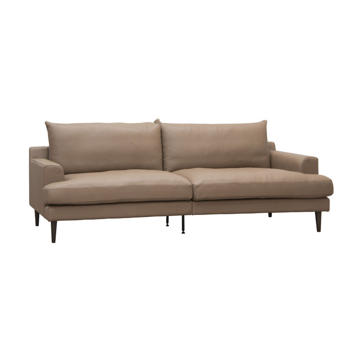 Leon sofa i taupe skinn med løse puter og mørke treben, sett skrått mot hvit bakgrunn.