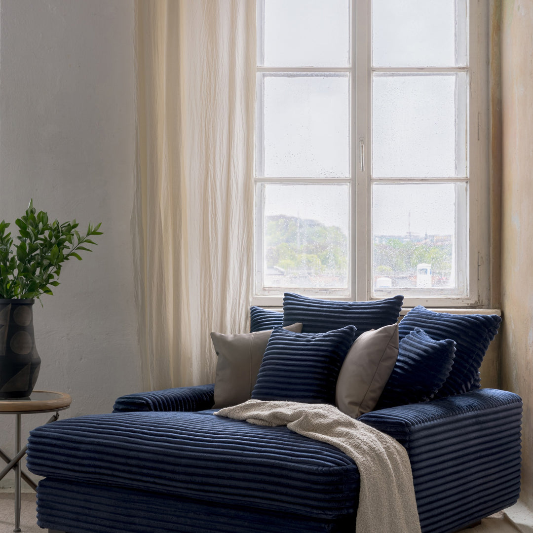 Tuva Xdeep daybed i marineblå kordfløyel ved vindu, med grønn plante og lyse gardiner