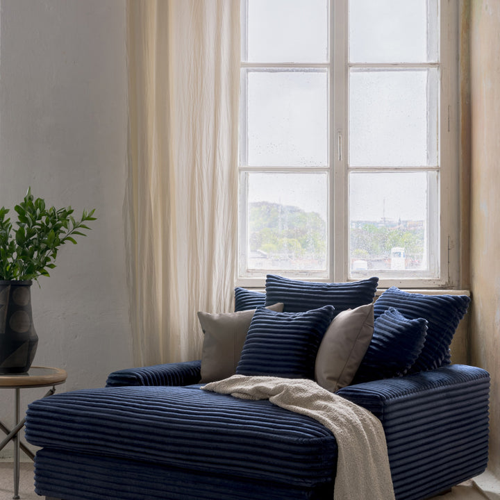 Tuva Xdeep daybed i marineblå kordfløyel ved vindu, med grønn plante og lyse gardiner