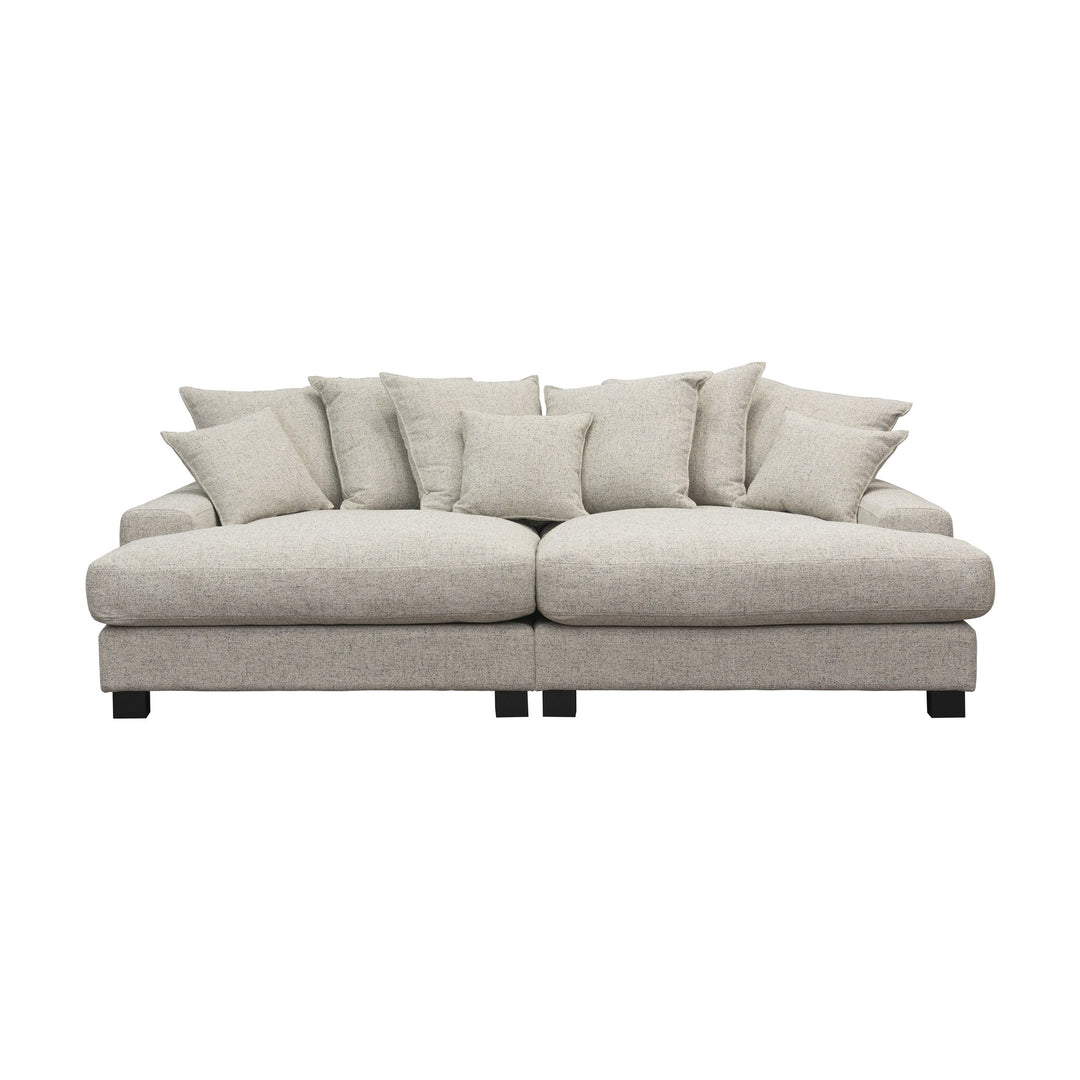 Tuva Xdeep daybed i lys beige strukturstoff med mange puter, sett forfra mot hvit bakgrunn.