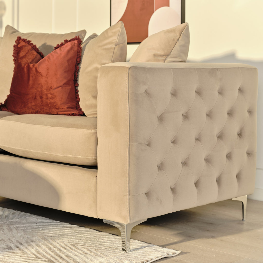 Fryns putetrekk i brent rust velur med frynser på beige sofa i stue med grafisk veggbilde.