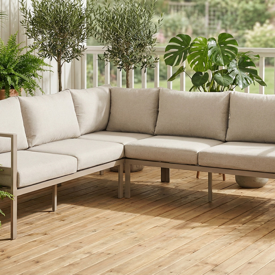 Dover sofa i taupe, modulær utesofa på en terrasse med oliventrær og grønne planter