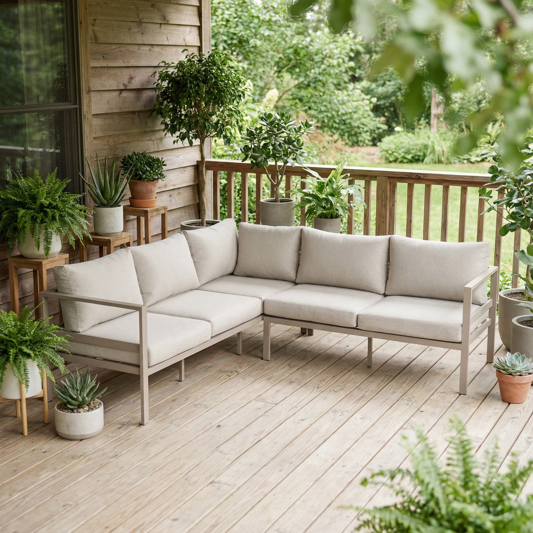 Dover hjørnesofa i taupe med beige puter på terrasse med potteplanter mot panelvegg
