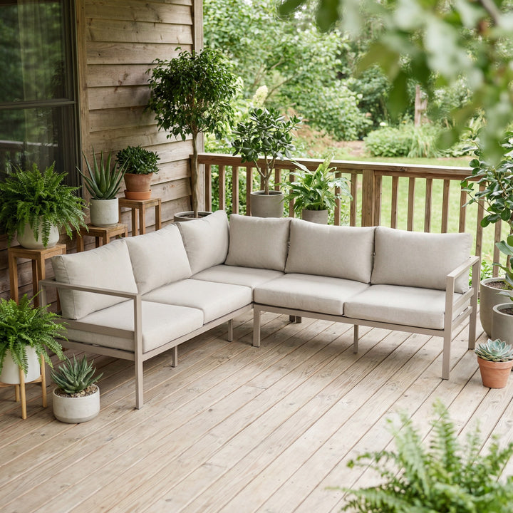 Dover hjørnesofa i taupe med beige puter på terrasse med potteplanter mot panelvegg