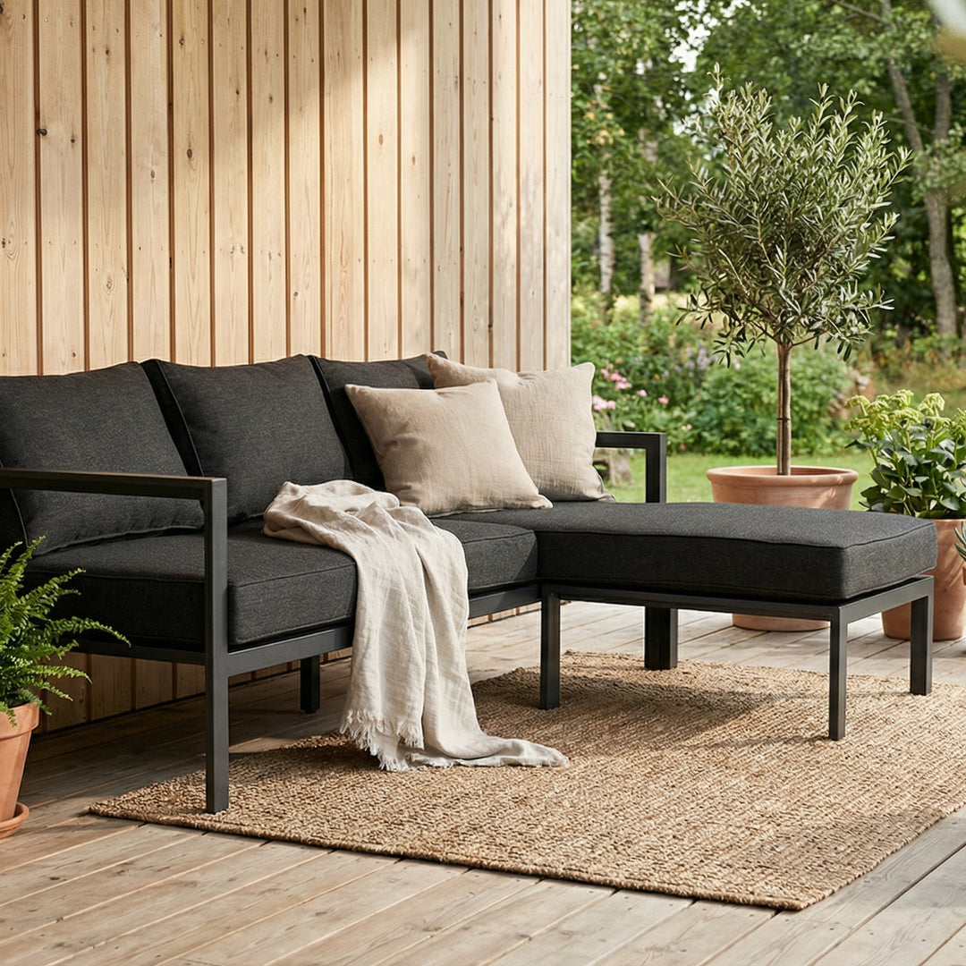 Brafab Delia utesofa i sort med antrasitt puter på terrasse, oliventre og beige pynteputer
