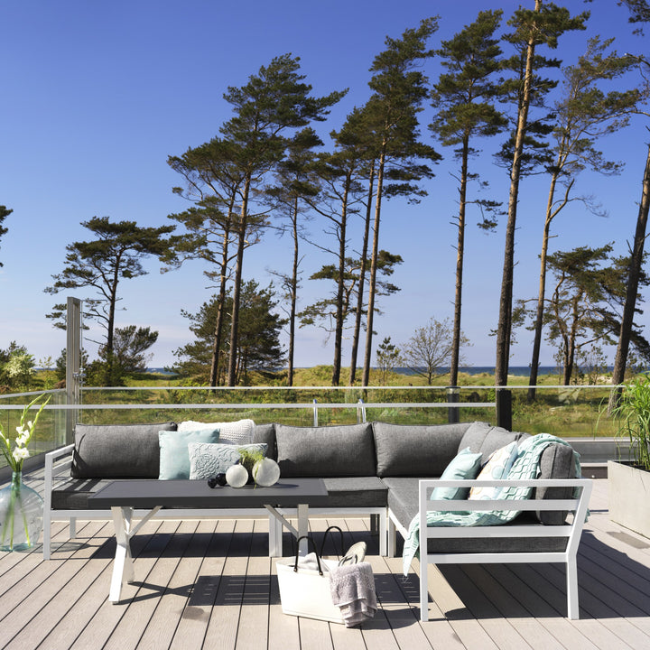 Brafab Weldon utesofa med hvit ramme og grå puter, mintgrønne pynteputer, terrasse ved sjø med furu