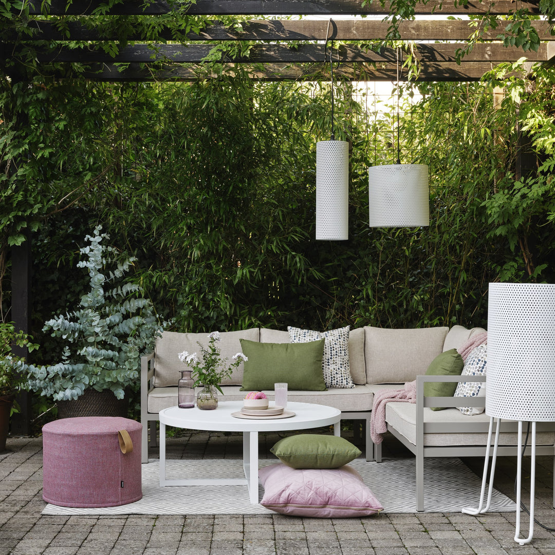 Brafab Weldon utesofa med khakifarget ramme og lyse puter, grønne og rosa pynteputer, under pergola