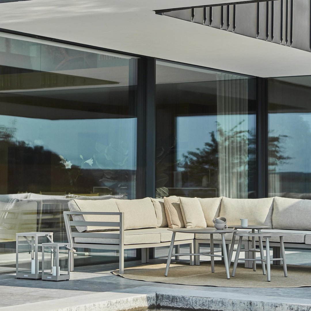 Brafab Weldon utesofa med lyse puter på terrasse, settbord og sjøutsikt