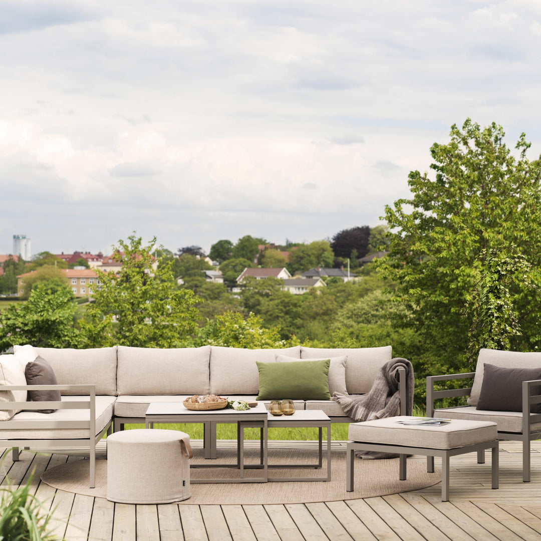 Brafab Weldon utesofa med beige puter på terrasse med utsikt, puff og settbord