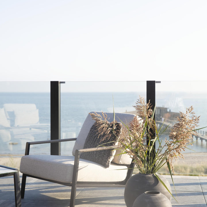 Brafab Lyra hagestol med lys grå pute på terrasse, sort ramme og havutsikt