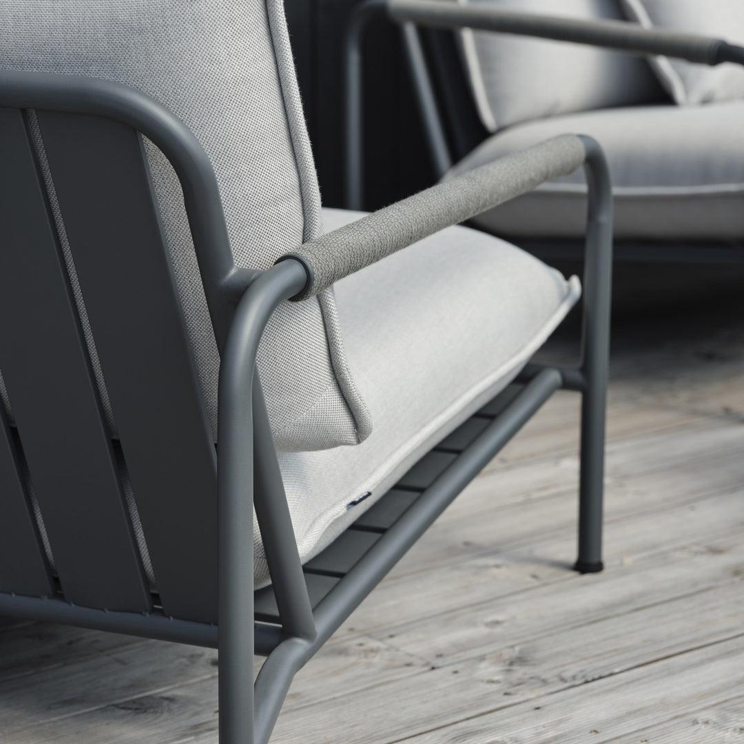 Brafab Lerberget hagestol, detalj av antrasitt ramme, armlene og lys grå sittepute på terrassedekke