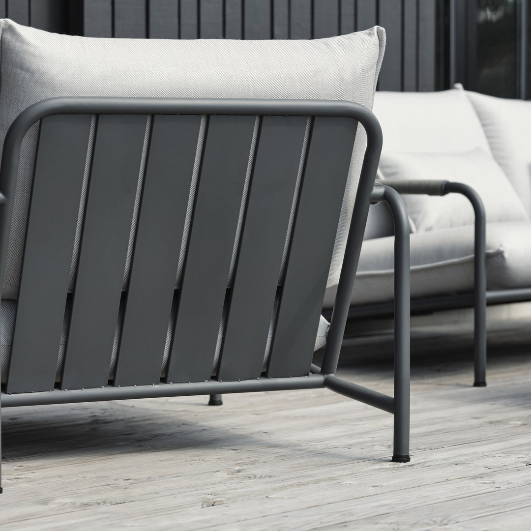 Brafab Lerberget hagestol i antrasitt sett fra siden på terrasse med lyse puter og mørk vegg bak