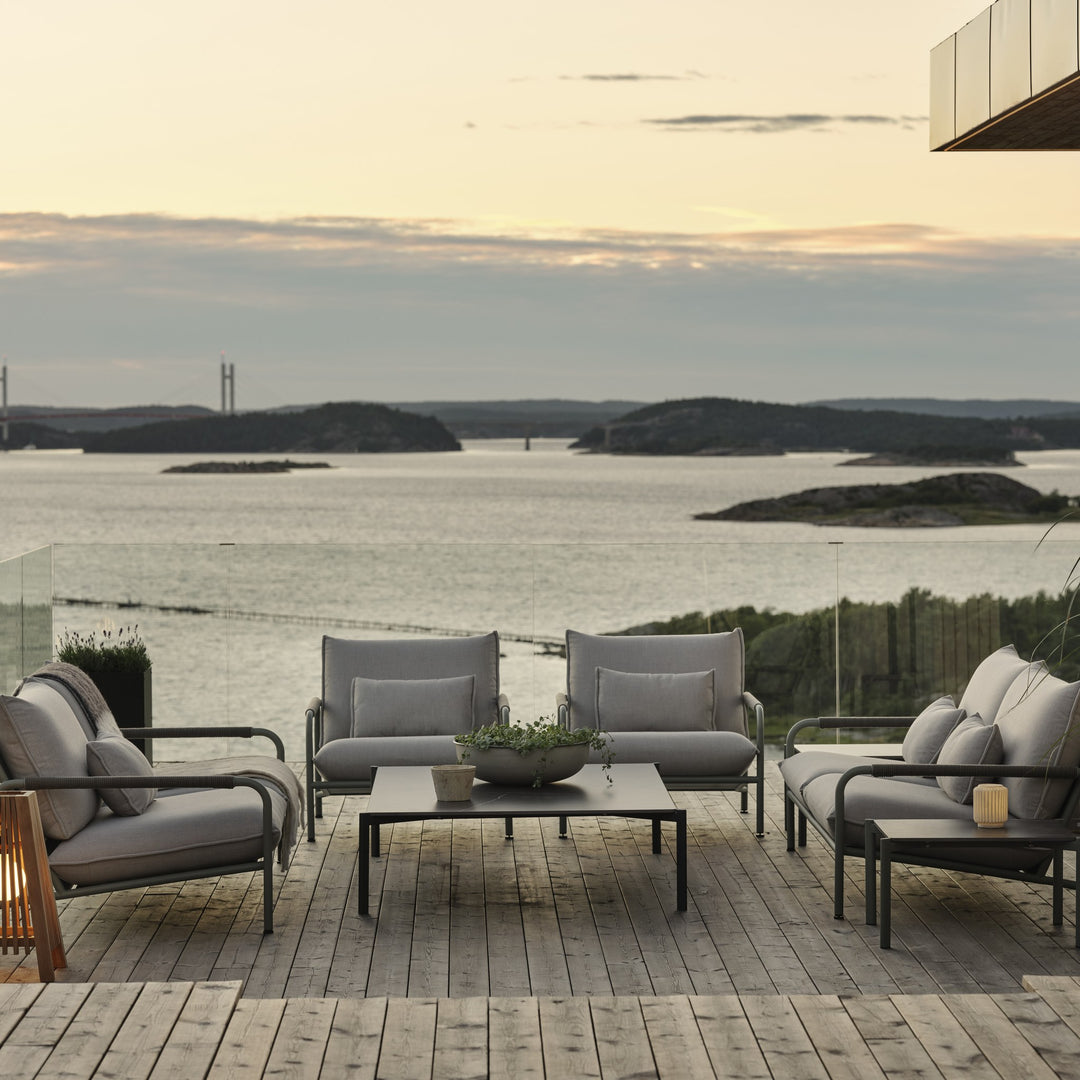 Brafab Lerberget loungegruppe på terrasse i skumring med utsikt over skjærgård og lysende trelykter