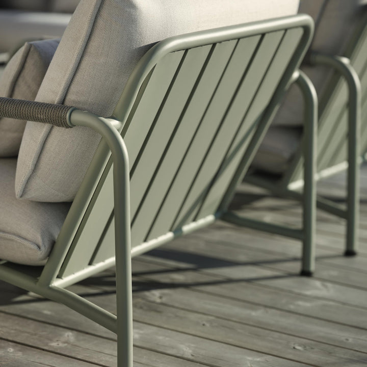 Brafab Lerberget hagestol i dusty green sett bakfra med spilerygg og beige puter i sollys på terrasse