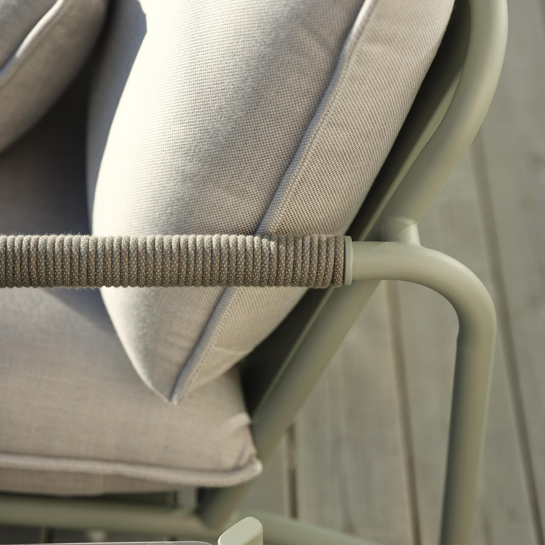 Brafab Lerberget hagestol i dusty green, nærbilde av tauviklet armlene og grå puter på terrasse