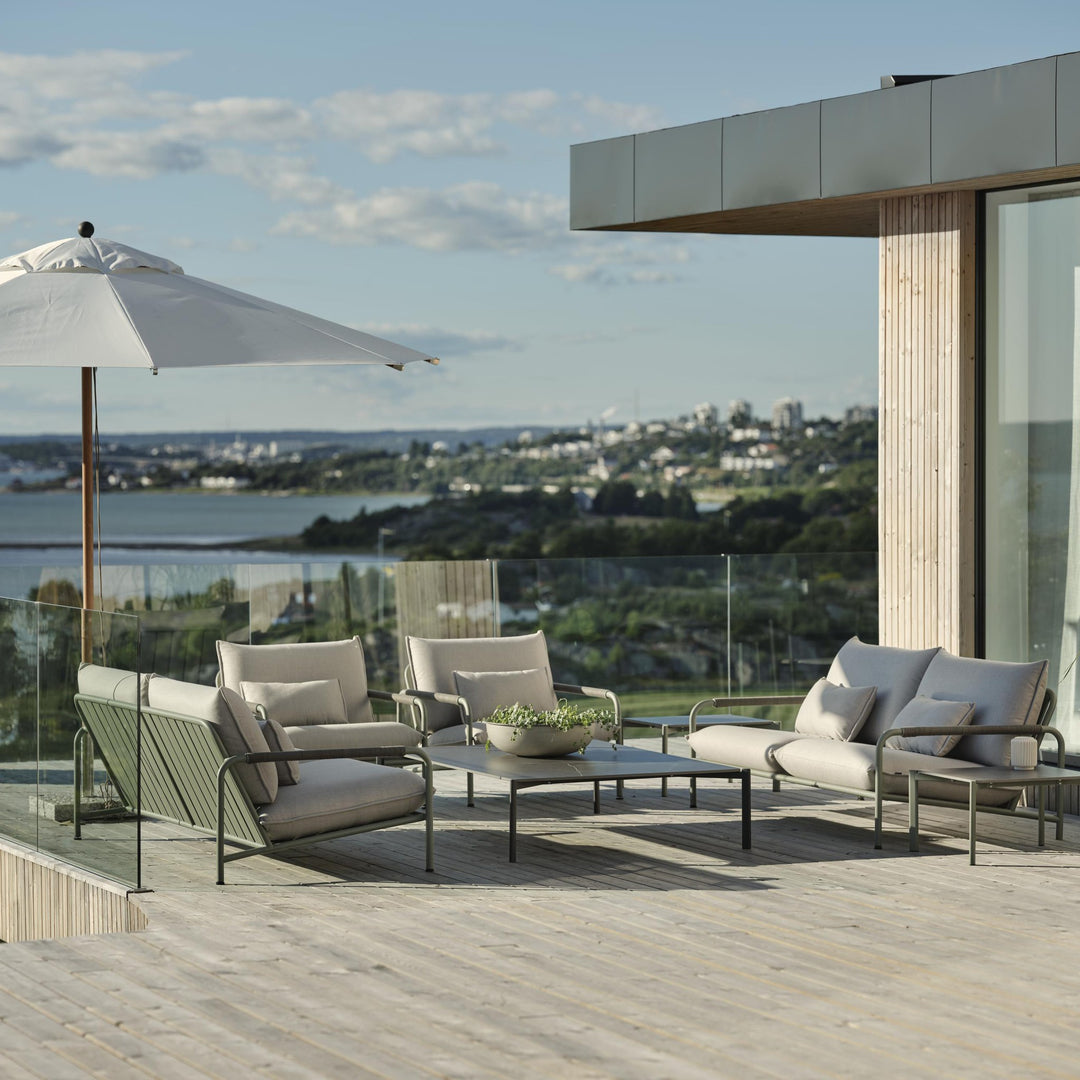 Brafab Lerberget loungeserie i dusty green på terrasse med parasoll og utsikt over fjord