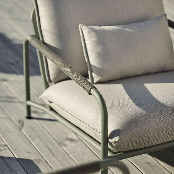 Brafab Lerberget hagestol i dusty green med beige puter, nærbilde i sollys på terrasse