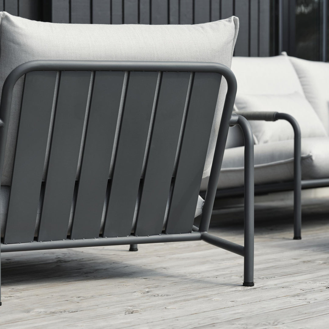 Brafab Lerberget hagestol i antrasitt sett bakfra på terrasse, lyse puter og utesofa bak