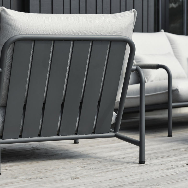 Brafab Lerberget hagestol i antrasitt sett bakfra på terrasse, lyse puter og utesofa bak