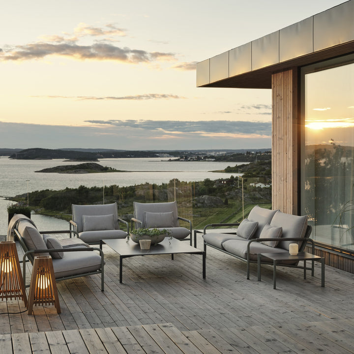 Brafab Lerberget loungeserie i dusty green på terrasse i solnedgang med salongbord og sjøutsikt