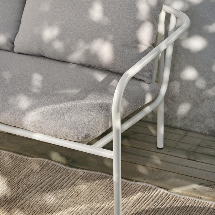 Brafab Bendt sofa, nærbilde av hvit ramme og gråbeige pute med solflekker på tredekke
