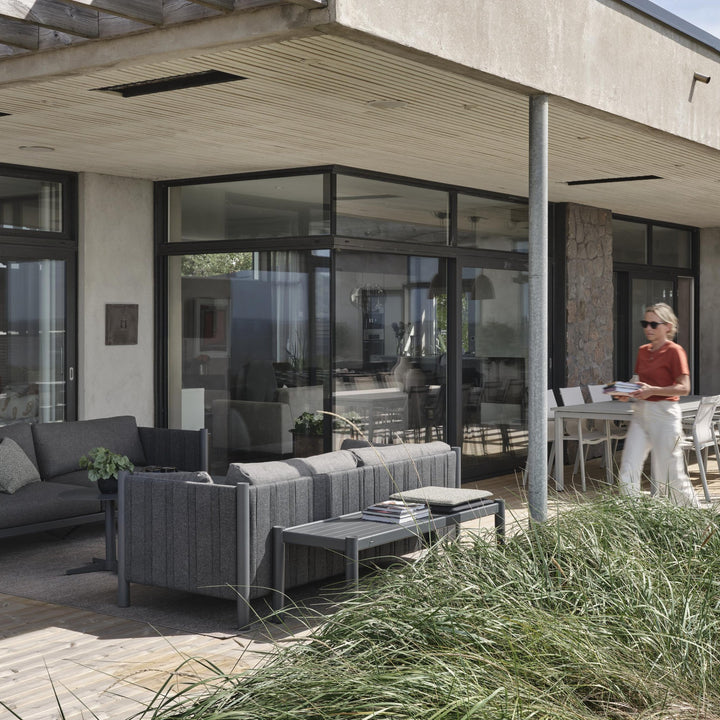 Brafab Brad loungesofa i antrasitt på terrasse med spisebord og strandgress