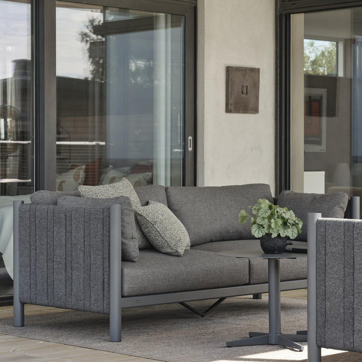 Brafab Brad loungesofa i antrasitt på terrasse med sidebord, plante og skyvedører