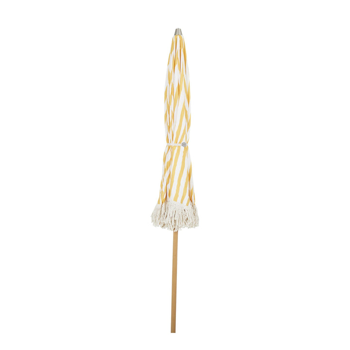 Brafab Gatsby parasoll sammenslått, gulstripet stoff med frynser og trestolpe mot hvit bakgrunn