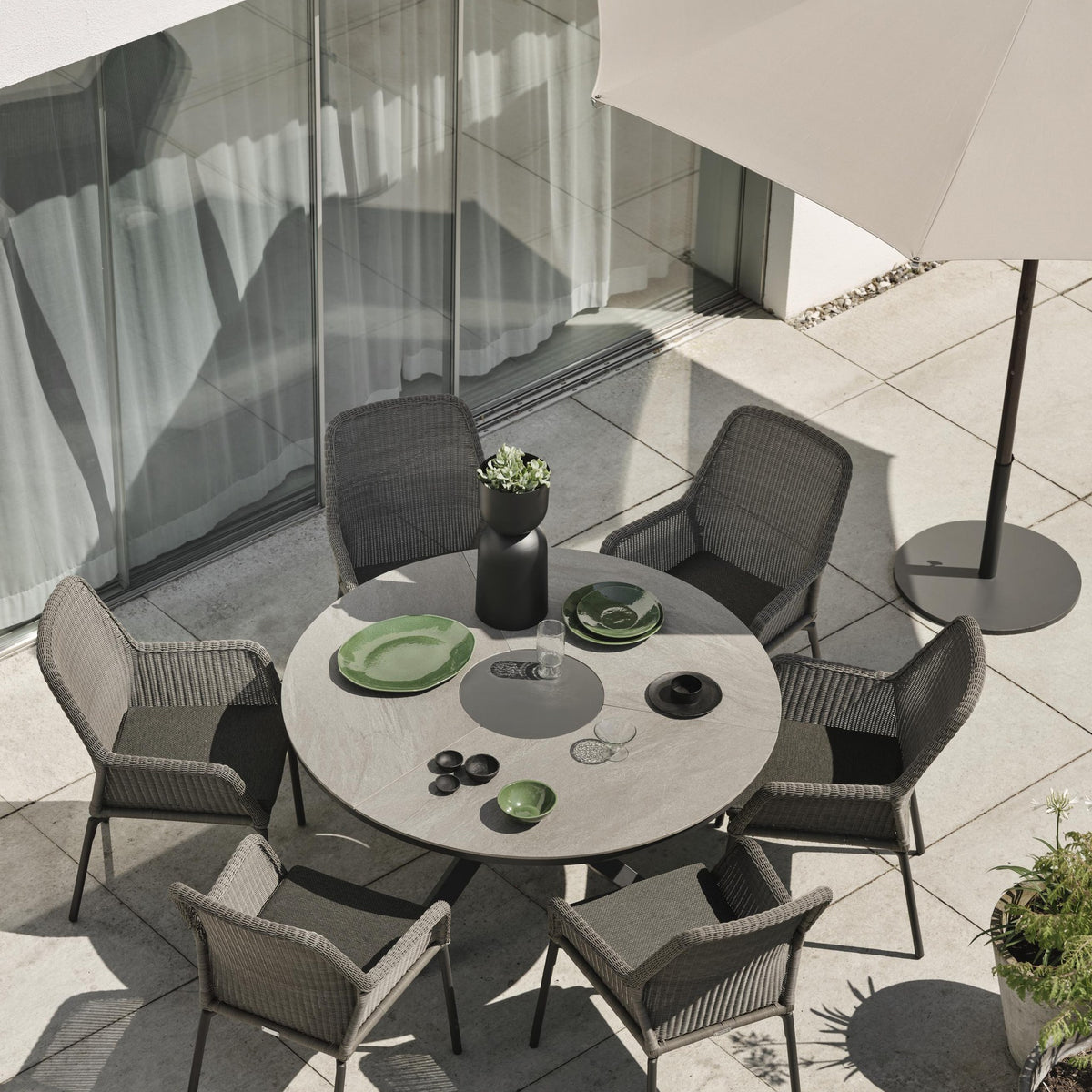 Brafab Flat parasollfot i mørk grå på terrasse med grå kurvstoler og rundt bord