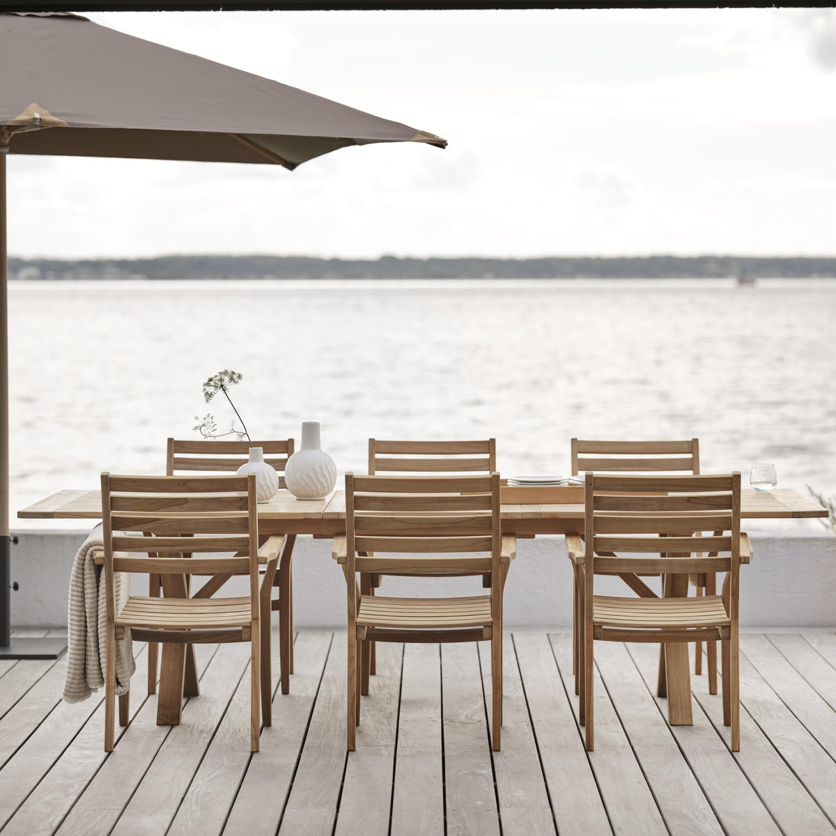 Brafab Flat parasollfot med teak spisegruppe på terrasse ved sjøen, taupe parasoll