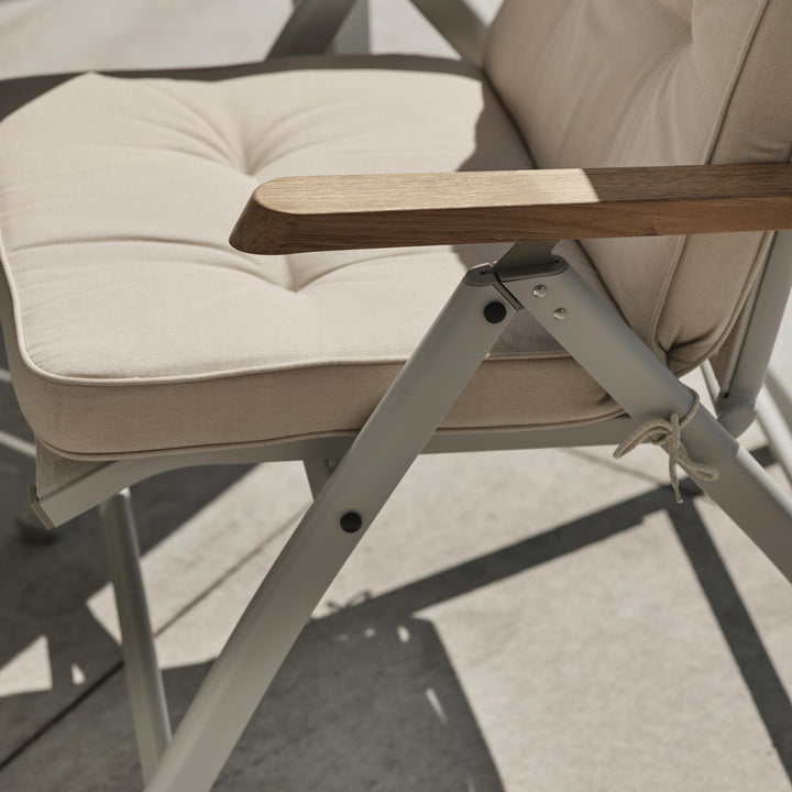 Brafab Andy spisestol med beige setepute og teak armlen, nærbilde på terrasse