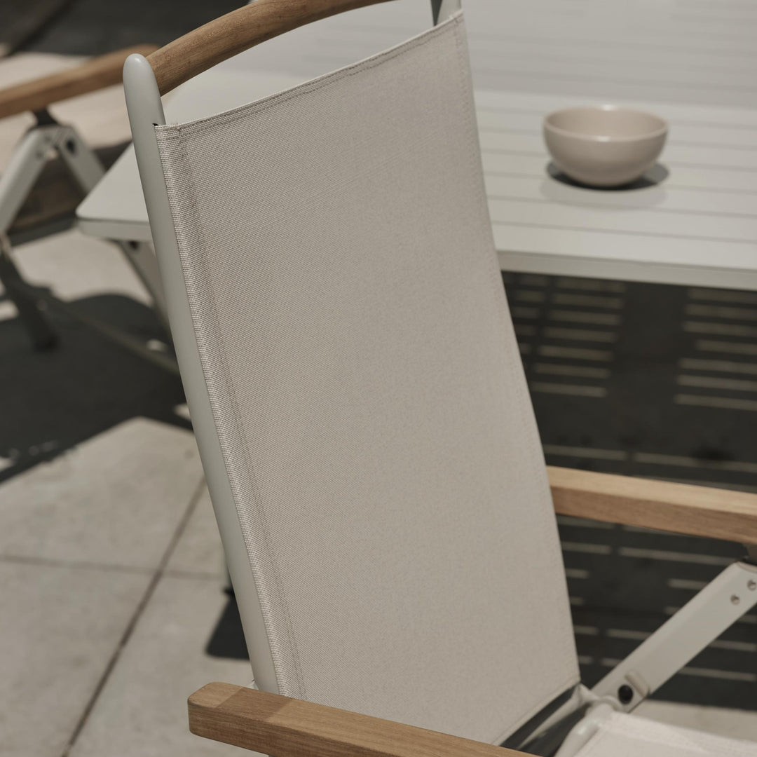 Brafab Andy spisestol med gråbeige tekstil ved hvitt bord med skål på terrasse