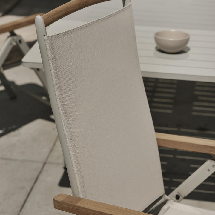Brafab Andy spisestol med gråbeige tekstil ved hvitt bord med skål på terrasse