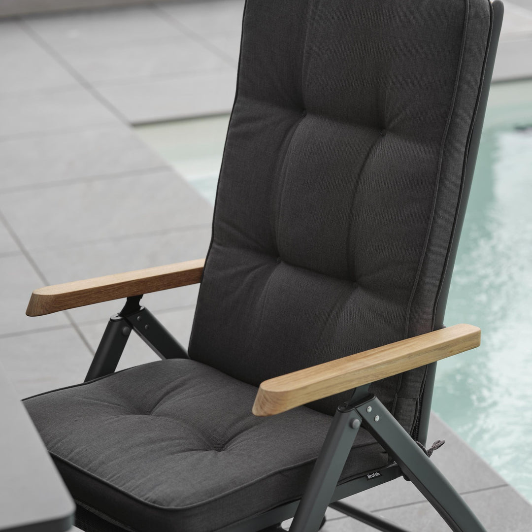 Brafab Andy spisestol med sort tekstil og teak armlener, sett bakfra ved basseng