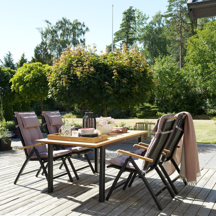 Brafab Andy spisestol i sort med teak armlener ved spisebord i solrik hage