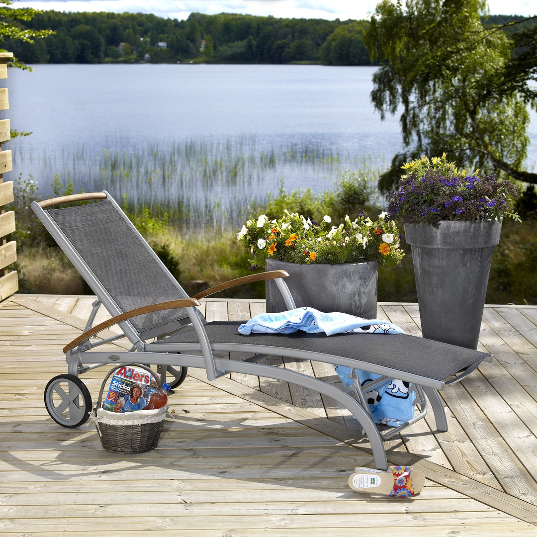Brafab Andy solseng med grå tekstil og teak armlener på terrasse ved vann
