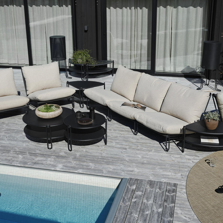 Brafab Blixt hagestol i sort med beige puter i loungesett på terrasse ved basseng