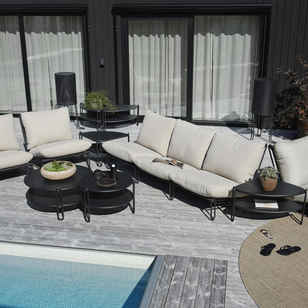 Brafab Blixt hagestol i sort med beige puter, loungesett på terrasse ved basseng med sandaler