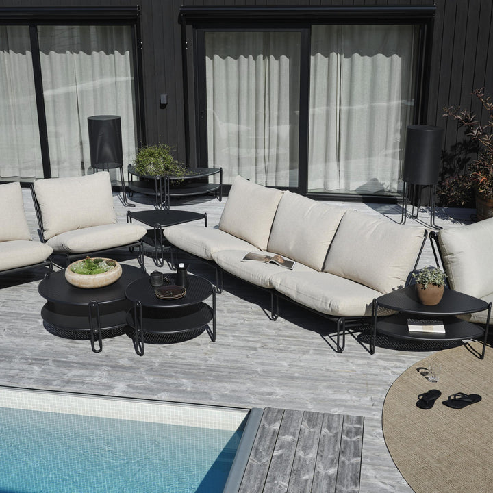 Brafab Blixt hagestol i sort med beige puter, loungesett på terrasse ved basseng med sandaler