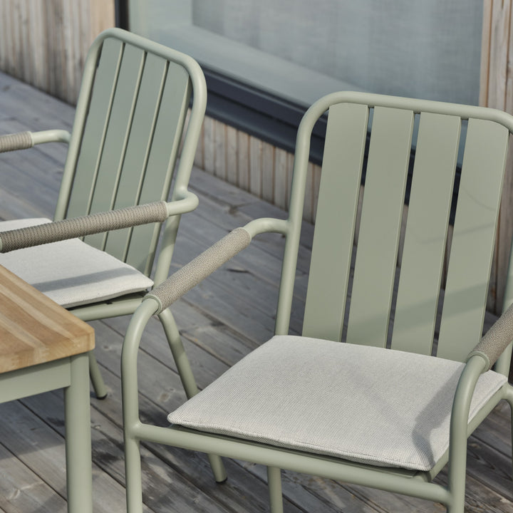 Brafab Innes spisestol i lys grønn med grå setepute ved teakbord på terrasse av tre