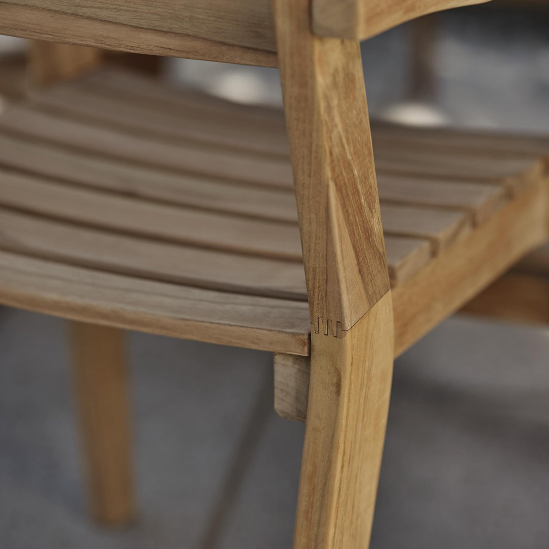 Brafab Keros spisestol i teak, nærbilde av buet spilesete på terrasse