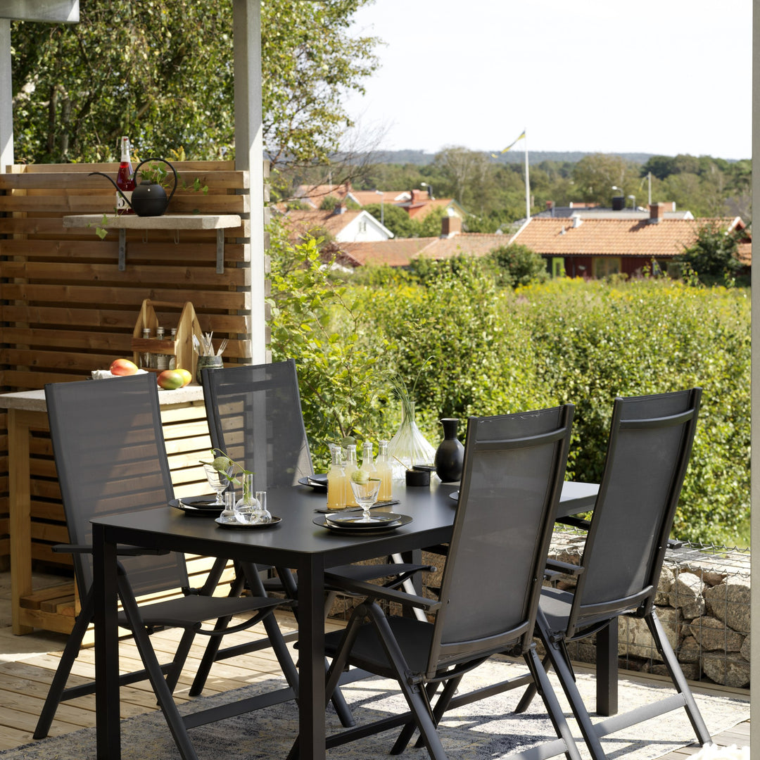 Brafab Rana spisestoler i sort med justerbar rygg på en terrasse med utsikt over landskapet.