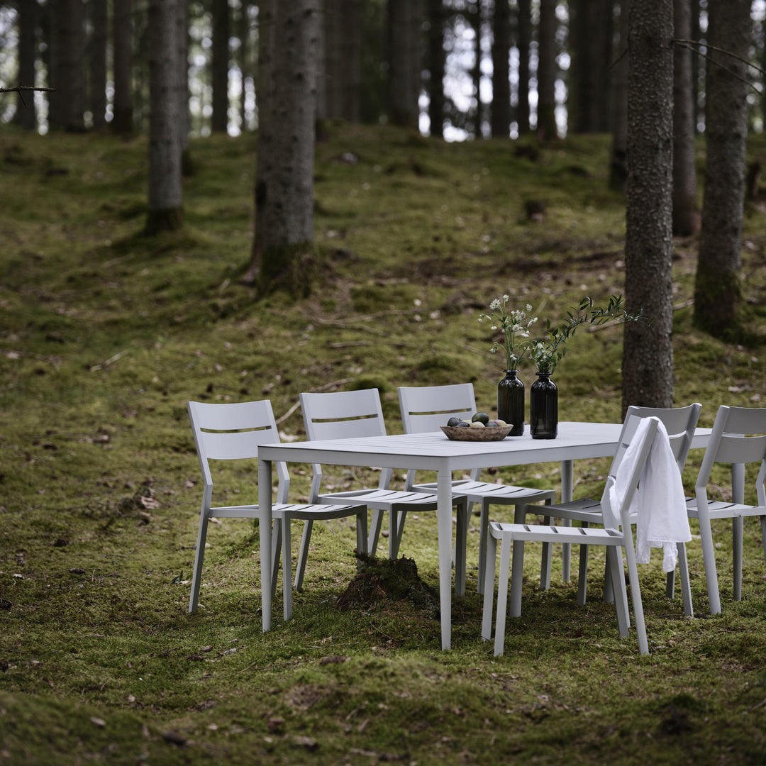 Brafab Delia spisestol uten armlene i lys grå, spisegruppe i skog med mose og grantrær