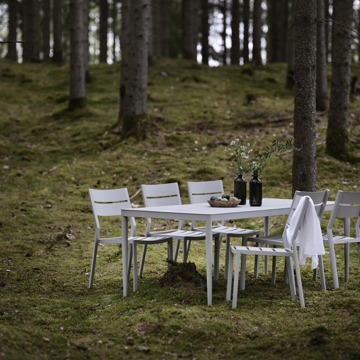 Brafab Delia spisestol uten armlene i lys grå, spisegruppe i skog med mose og grantrær