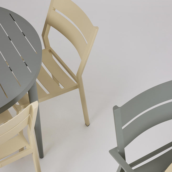 Brafab Delia spisestol uten armlene i lys gul ved grått bord, sett ovenfra mot hvit bakgrunn