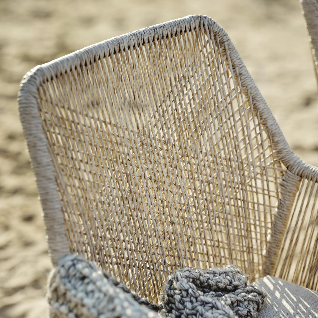 Brafab Midway spisestol, nærbilde av beige flettet tau med sand i bakgrunnen