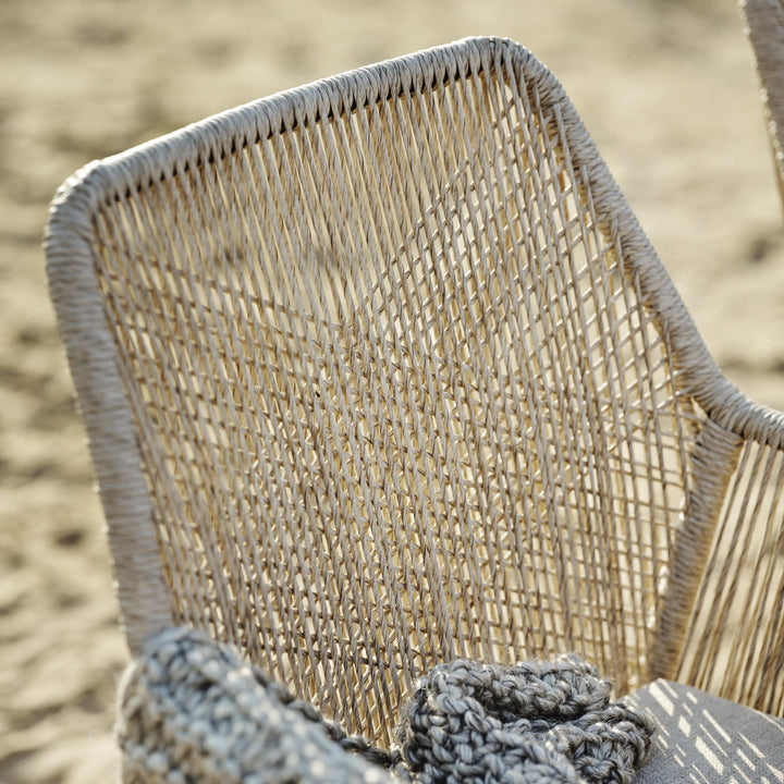 Brafab Midway spisestol, nærbilde av beige flettet tau med sand i bakgrunnen
