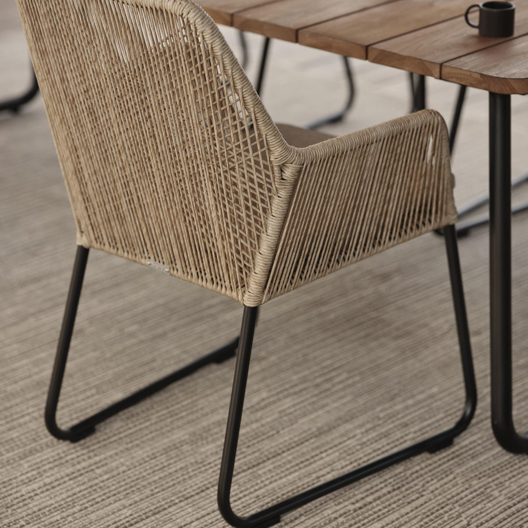 Brafab Midway spisestol i beige flettet tau inntil teakbord med kaffekopp
