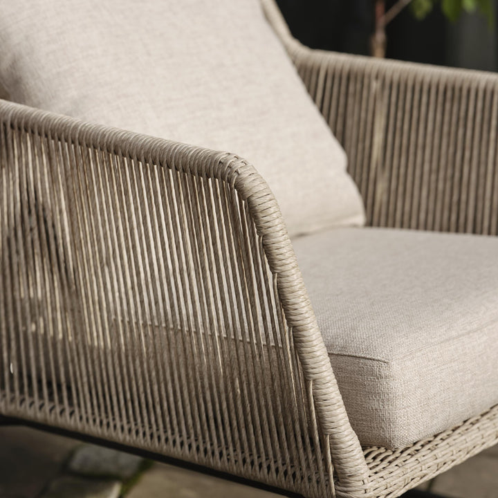 Brafab Midway loungestol, nærbilde av beige tauflett og lys pute utendørs med plante bak